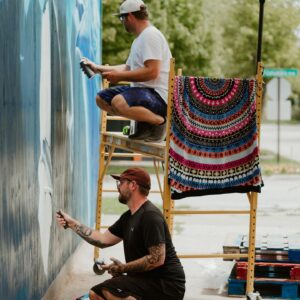 3Sixty volunteers work on a mural.